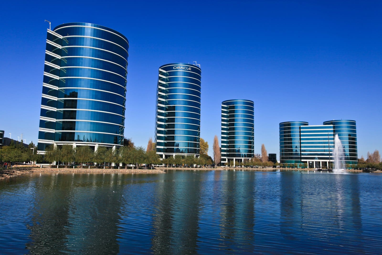 Torres de vidro azul da sede da Oracle em Redwood Shores, na Califórnia, refletidas em um lago