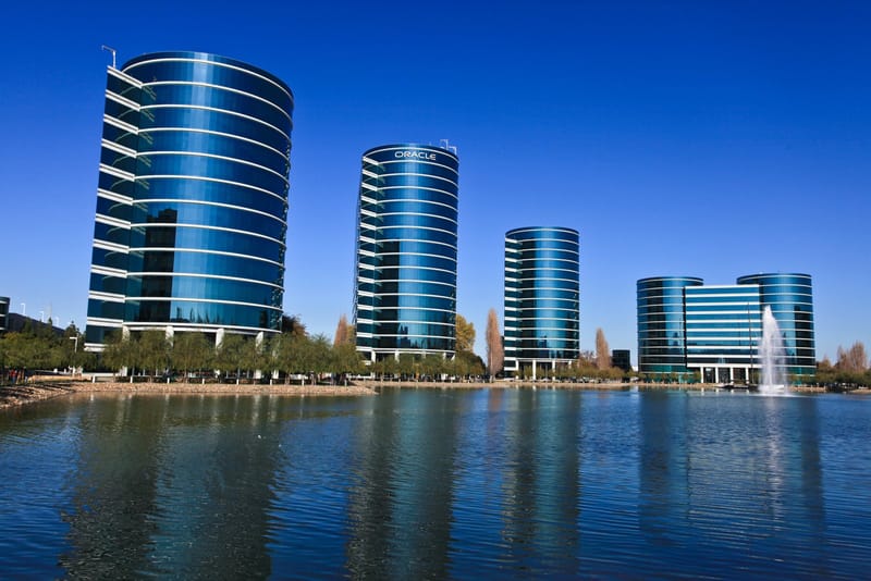 Torres de vidro azul da sede da Oracle em Redwood Shores, na Califórnia, refletidas em um lago